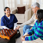 A woman in blue shirt playing checkers with two people.